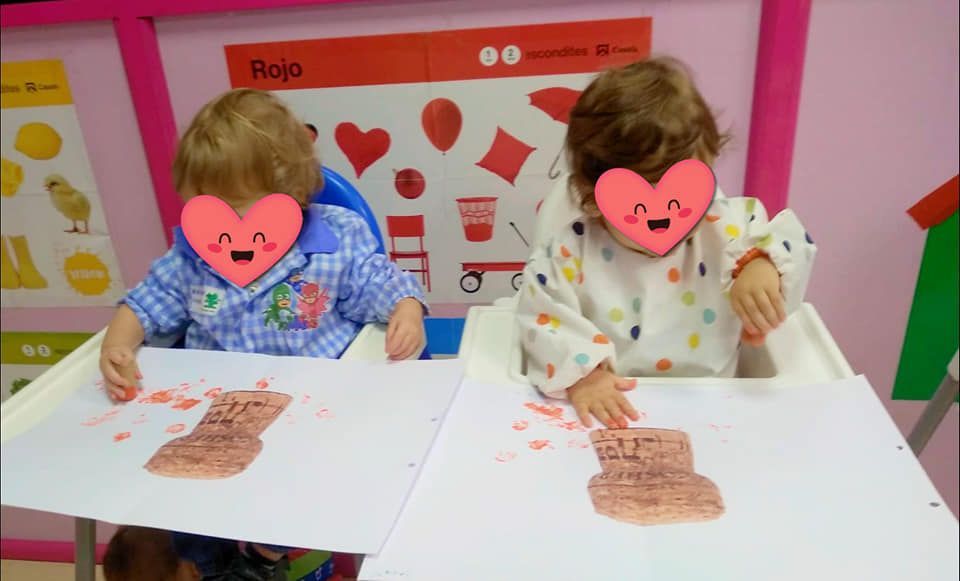 Dos niños están sentados en una mesa con un dibujo de un oso en ella.