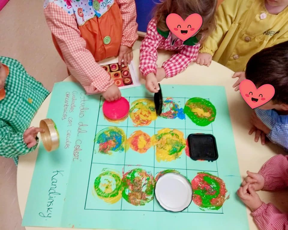Un grupo de niños están sentados alrededor de una mesa jugando un juego.