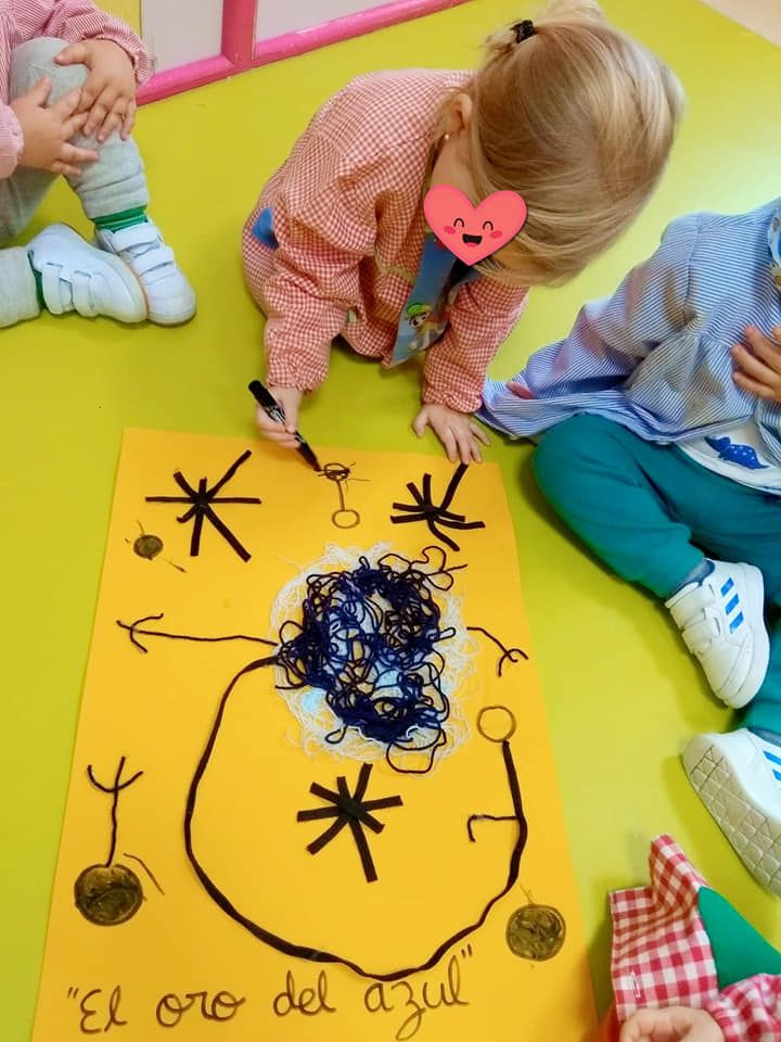 Un niño dibuja en un papel amarillo que dice el oro del azul.