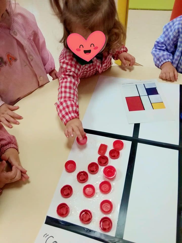 Una niña con un corazón en la cara está jugando con botones rojos.