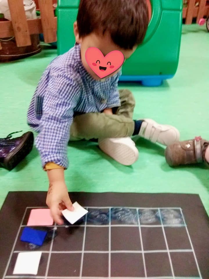 Un niño pequeño con un corazón en la cara está jugando con bloques.