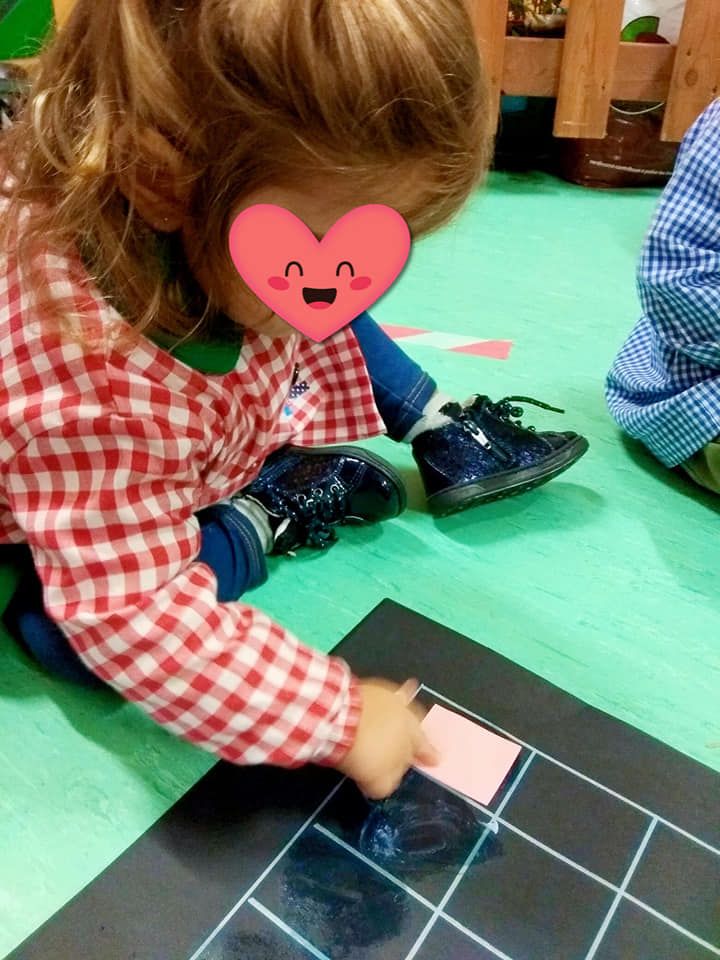 Una niña con un corazón en la cara está jugando con tiza.