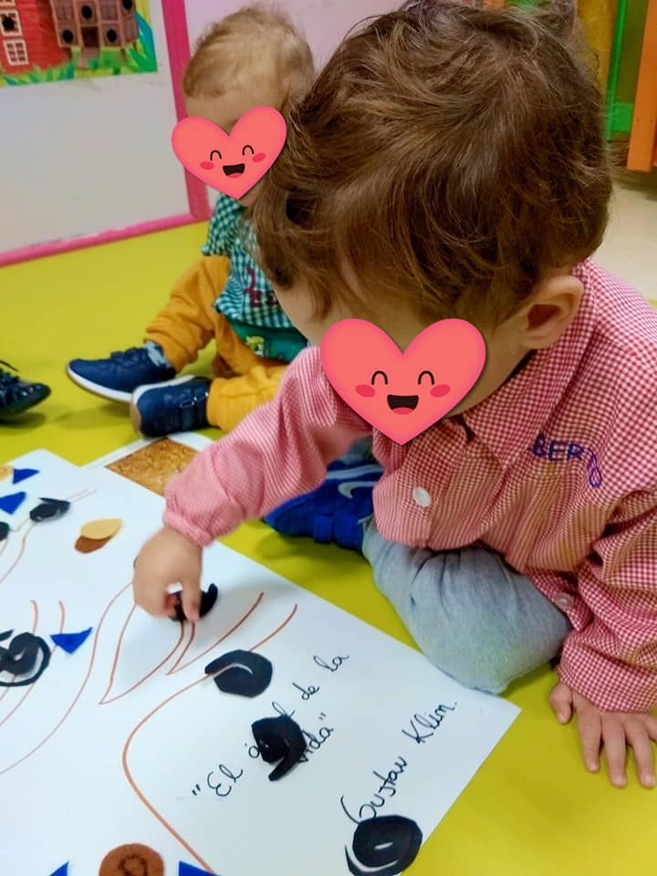 Un niño con un corazón en la cara está dibujando en un trozo de papel.