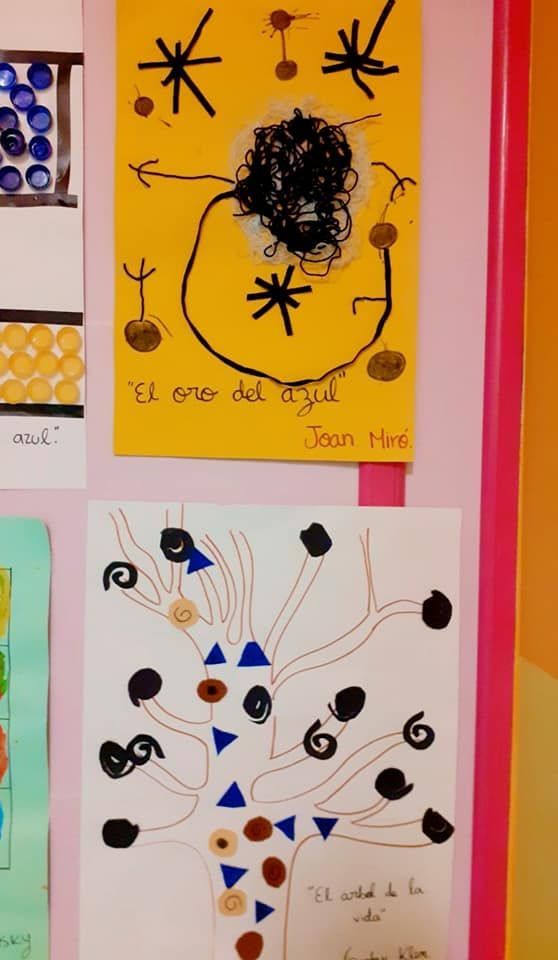 Un dibujo infantil de un árbol está colgado en una pared.