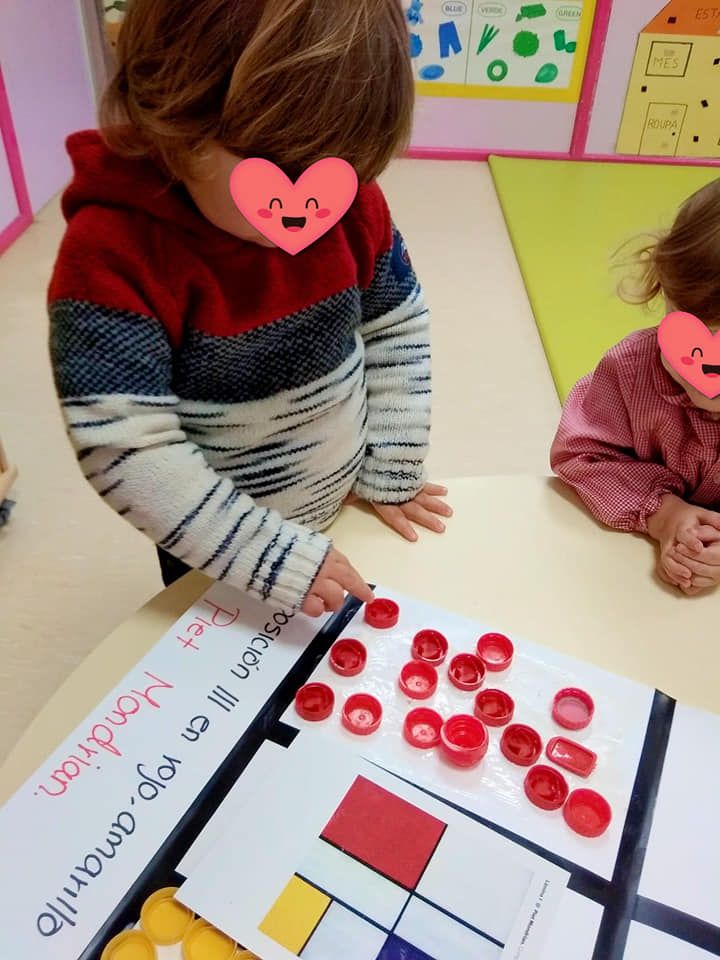 Una niña con un corazón en la cara está jugando con un libro.