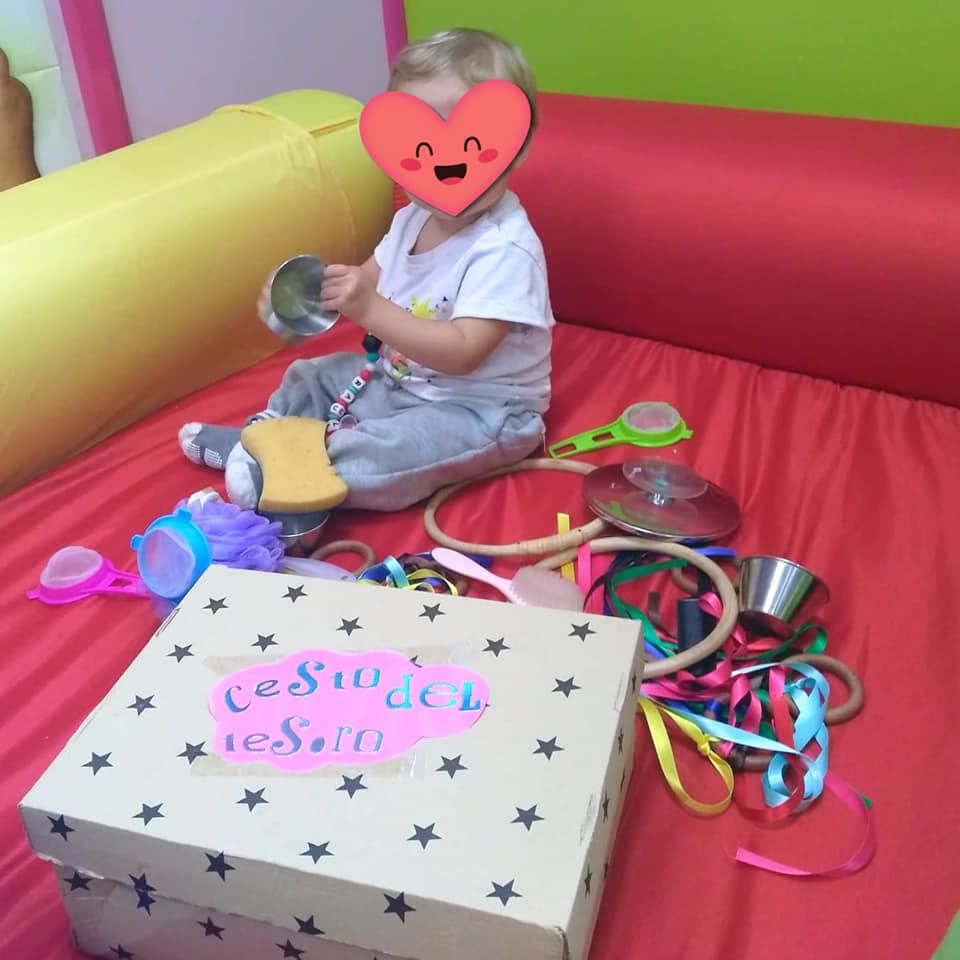 Un niño con un corazón en la cara se sienta en una cama junto a una caja que dice casa del resort