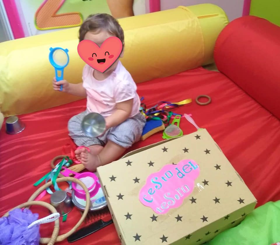 Una niña está jugando con juguetes y una caja que dice cesta del tesoro