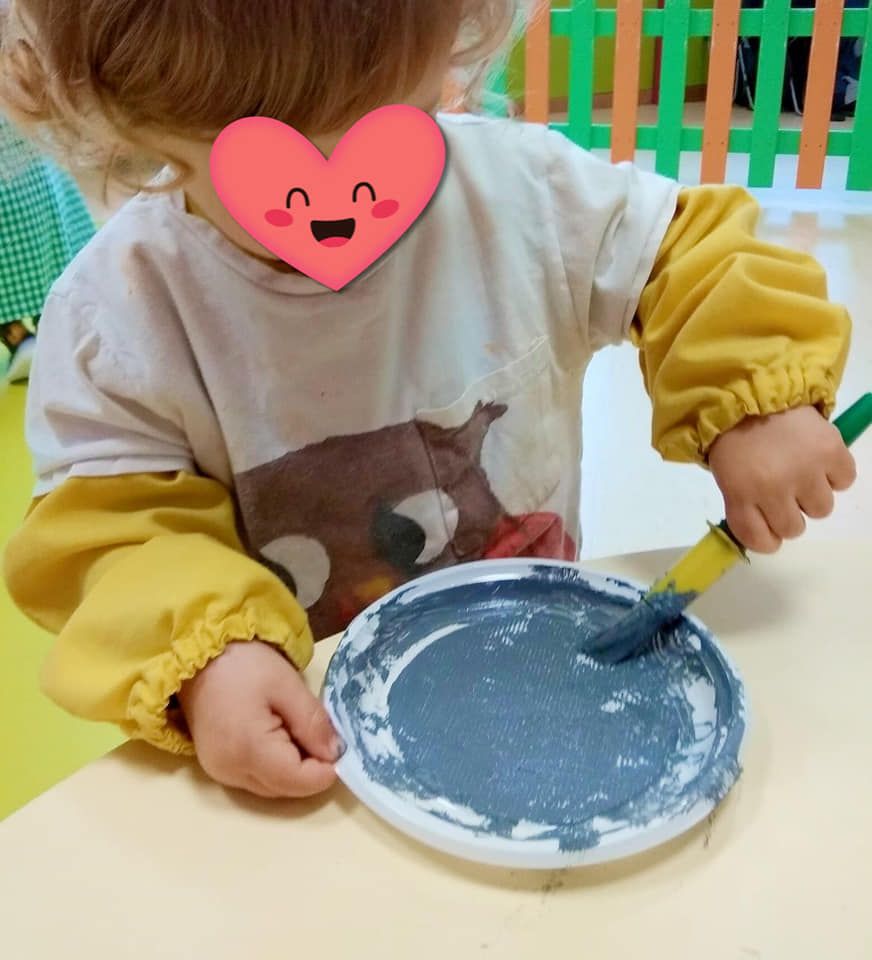 Una niña con un corazón en la cara está jugando con pintura.