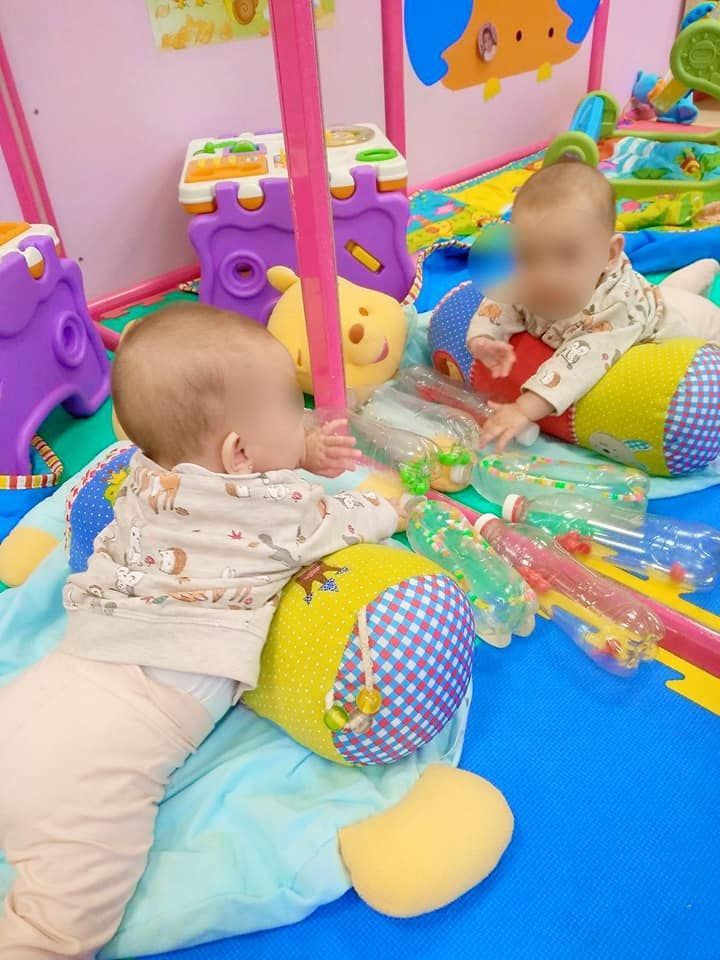 Un bebé está jugando con juguetes frente a un espejo.