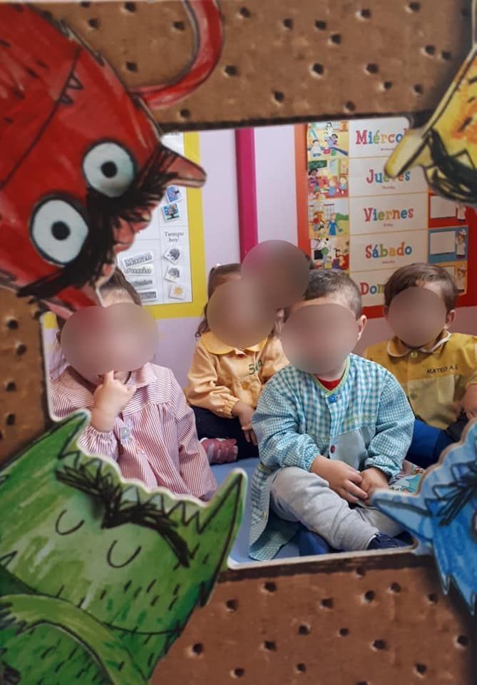 Un grupo de niños está sentado frente a una imagen de un monstruo.