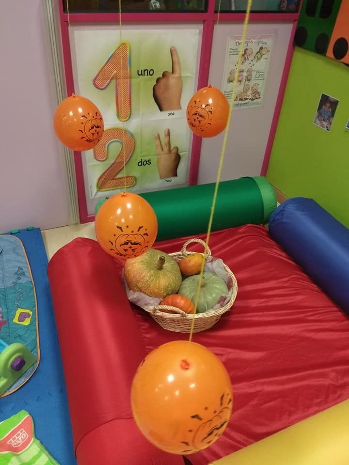 Una canasta de manzanas y calabazas colgando de una cuerda.