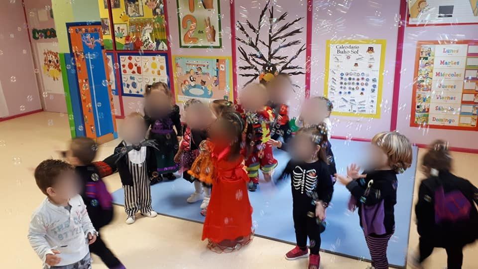 Un grupo de niños está jugando con burbujas de jabón en una habitación.