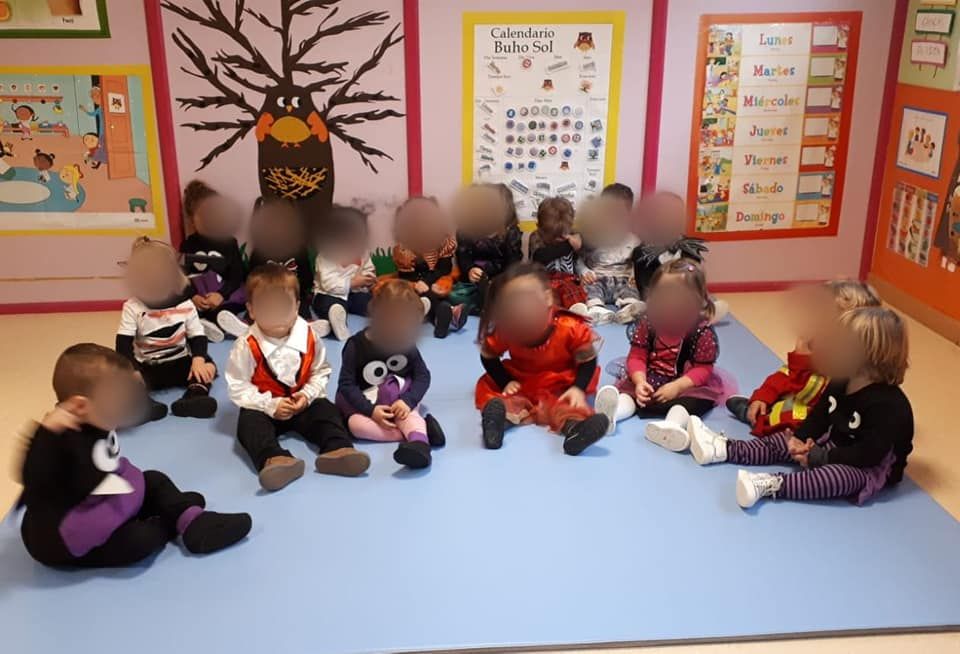 Un grupo de niños está sentado en el suelo en círculo.