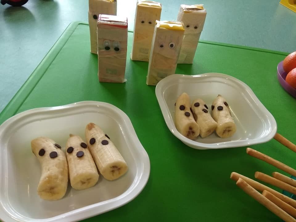 Tres platos de plátanos con chispas de chocolate sobre una mesa verde.