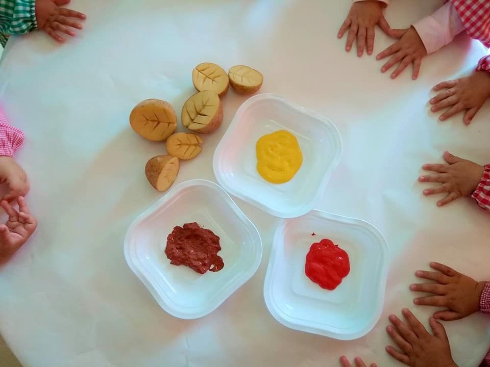 Un grupo de niños están sentados alrededor de una mesa con cuencos de comida.