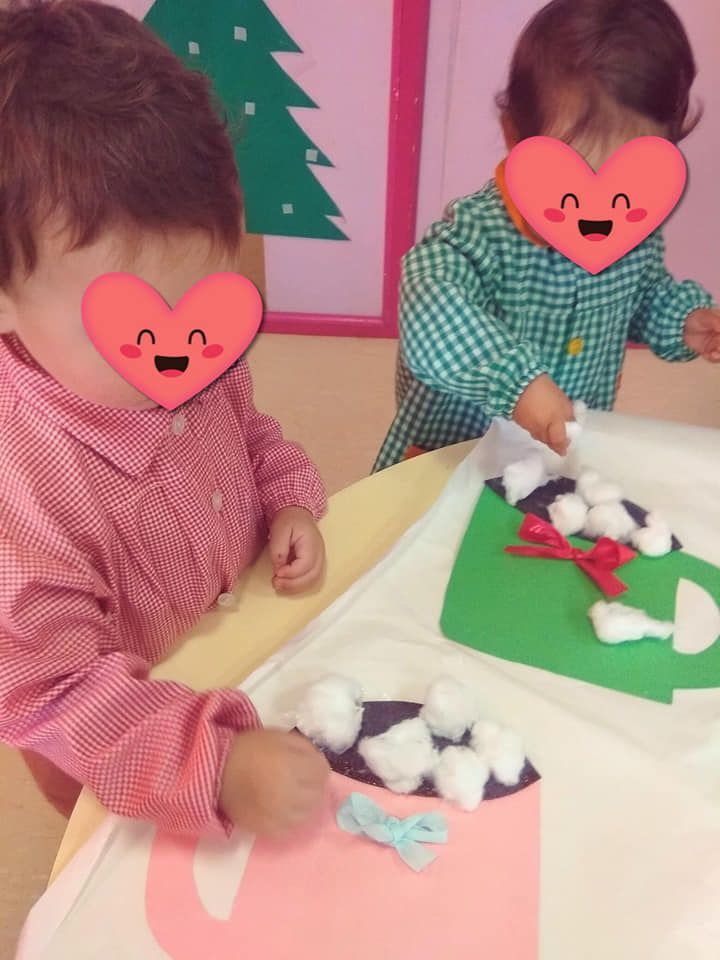 Dos niños con corazones en sus caras están jugando con bolas de algodón.