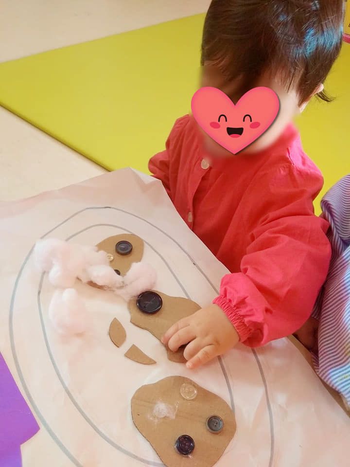 Una niña con un corazón en la cara está sentada en una mesa.