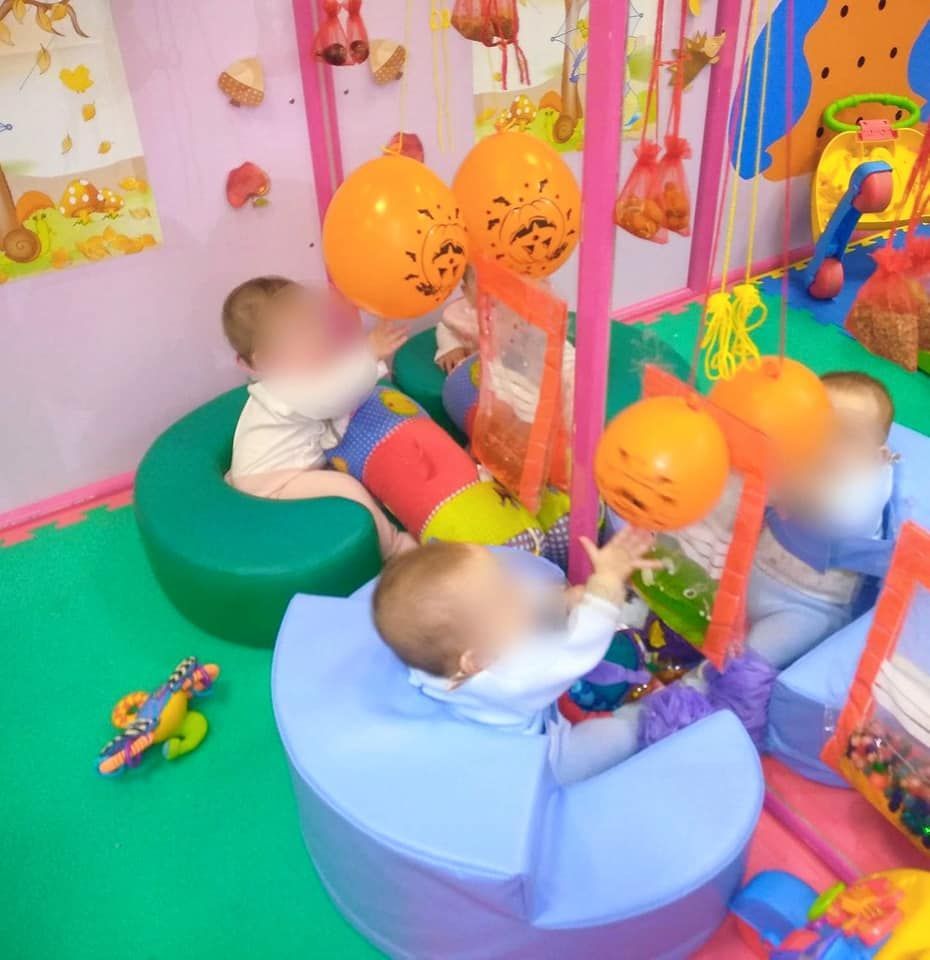 Un grupo de bebés está jugando con juguetes en una sala de juegos.