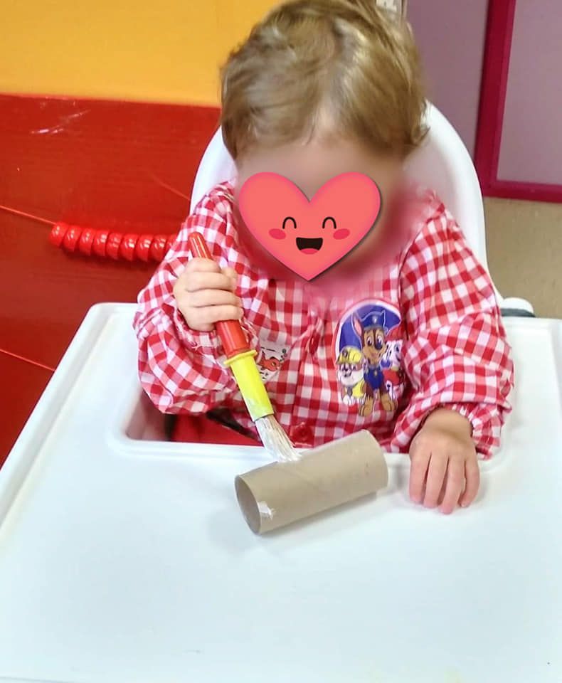 Un bebé en una silla alta con un corazón en la cara.