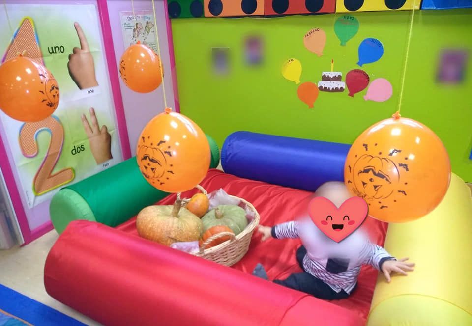 Un bebé está jugando con globos en una sala de juegos.