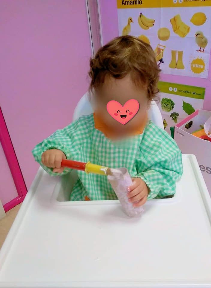 Un bebé en una silla alta con un corazón en la cara.