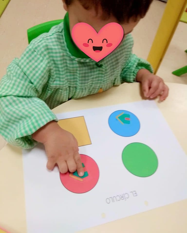 Un niño con un corazón en la cara está jugando con círculos.