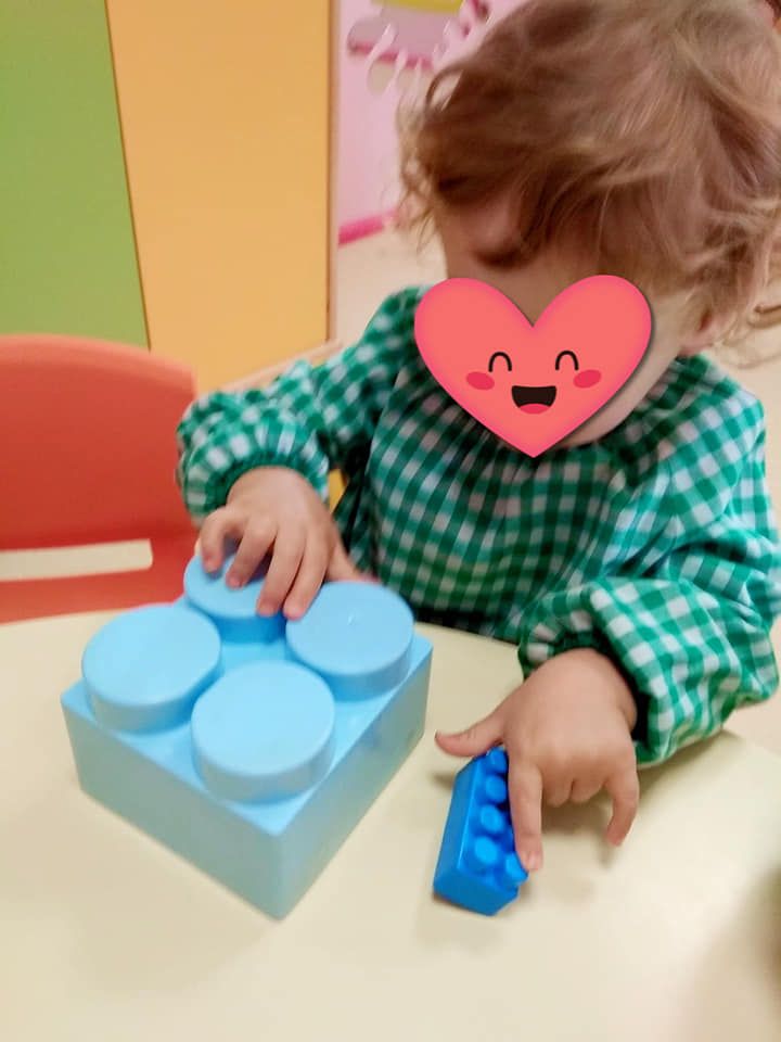 Una niña con un corazón en la cara está jugando con bloques.