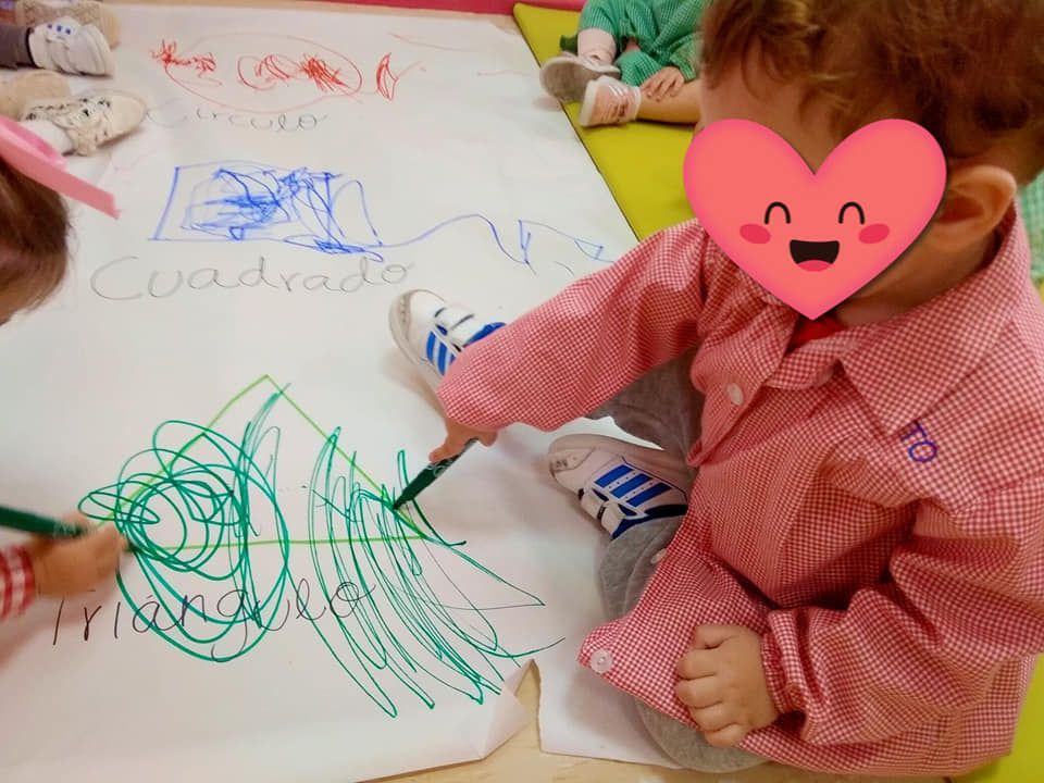Un niño con un corazón en la cara está dibujando en un trozo de papel.