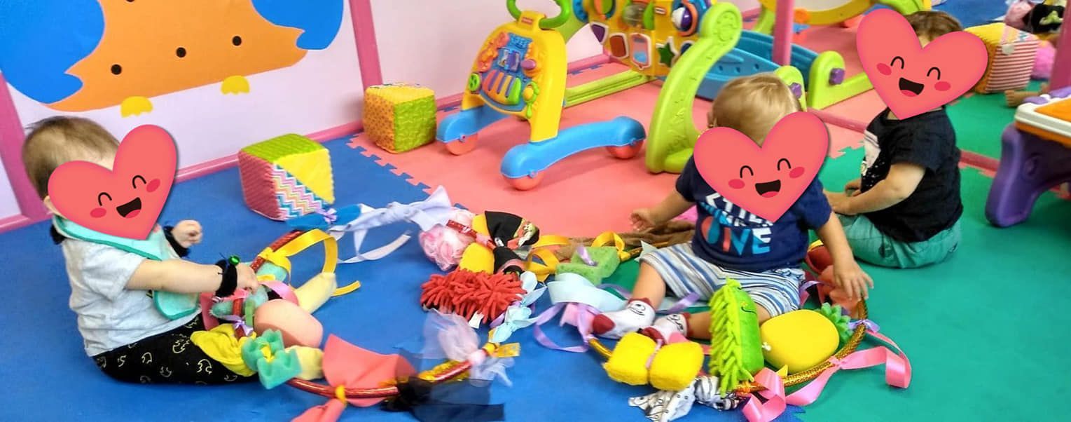 Un grupo de niños está sentado en el suelo jugando con juguetes.