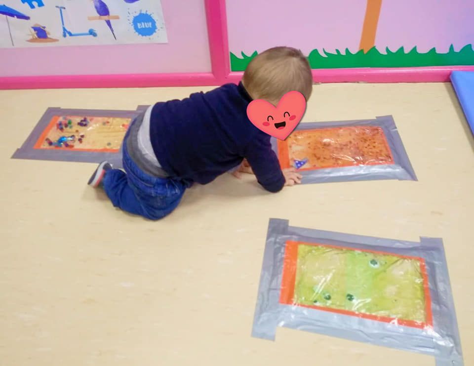 Un bebé con un corazón en la cara se arrastra por el suelo.