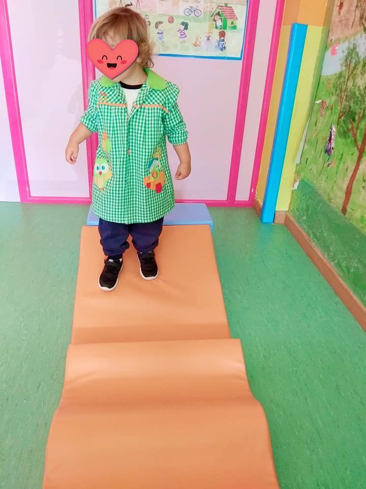 Un niño pequeño que lleva una máscara con forma de corazón está parado en una rampa.