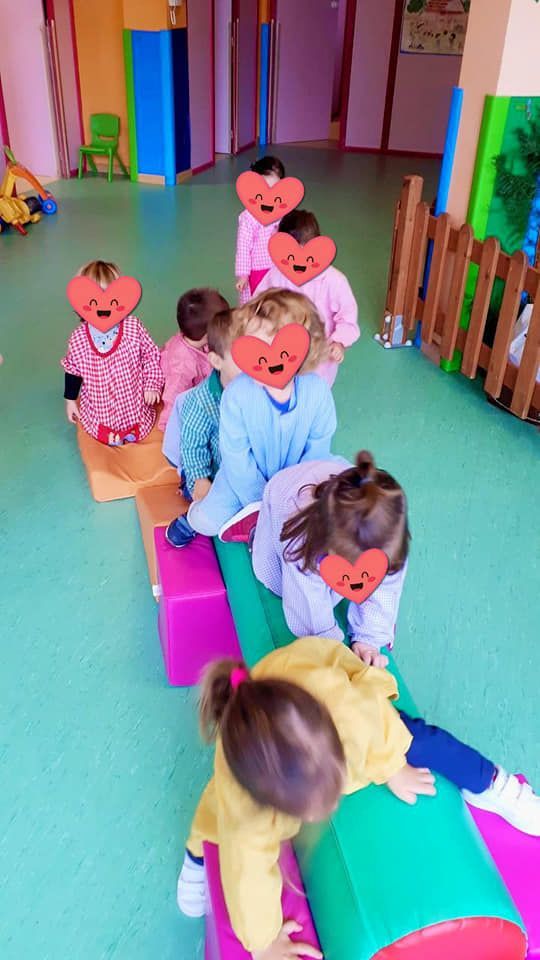 Un grupo de niños está jugando en una viga de equilibrio en una habitación.
