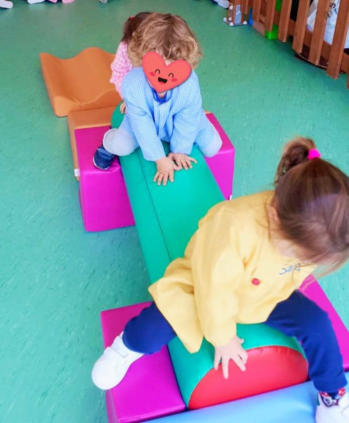Dos niñas están jugando con un bloque verde y rosa.