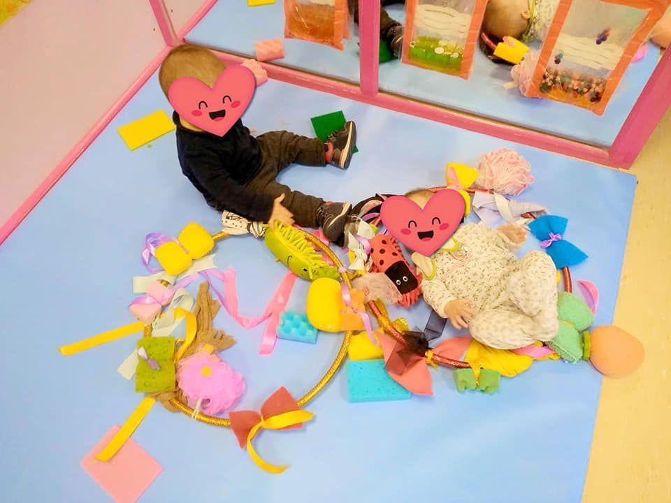 Un niño y una niña están acostados en el suelo jugando con juguetes.