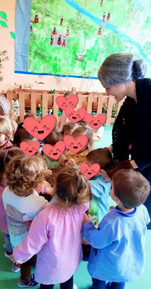 Una mujer está hablando con un grupo de niños en un aula.