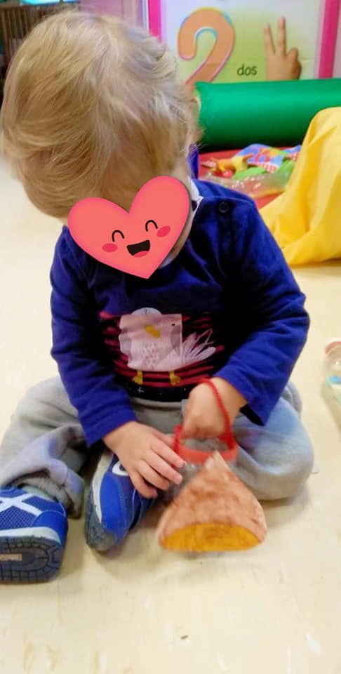 Un niño pequeño está sentado en el suelo con un corazón en el cuello.