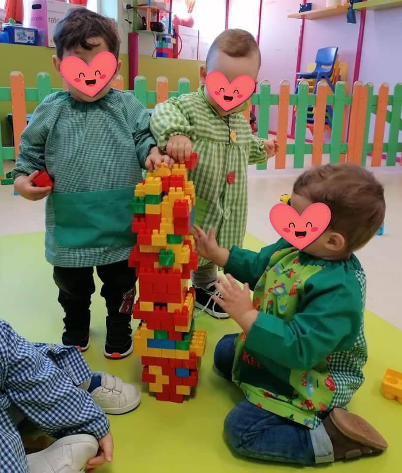 Un grupo de niños está jugando con una pila de bloques Lego.