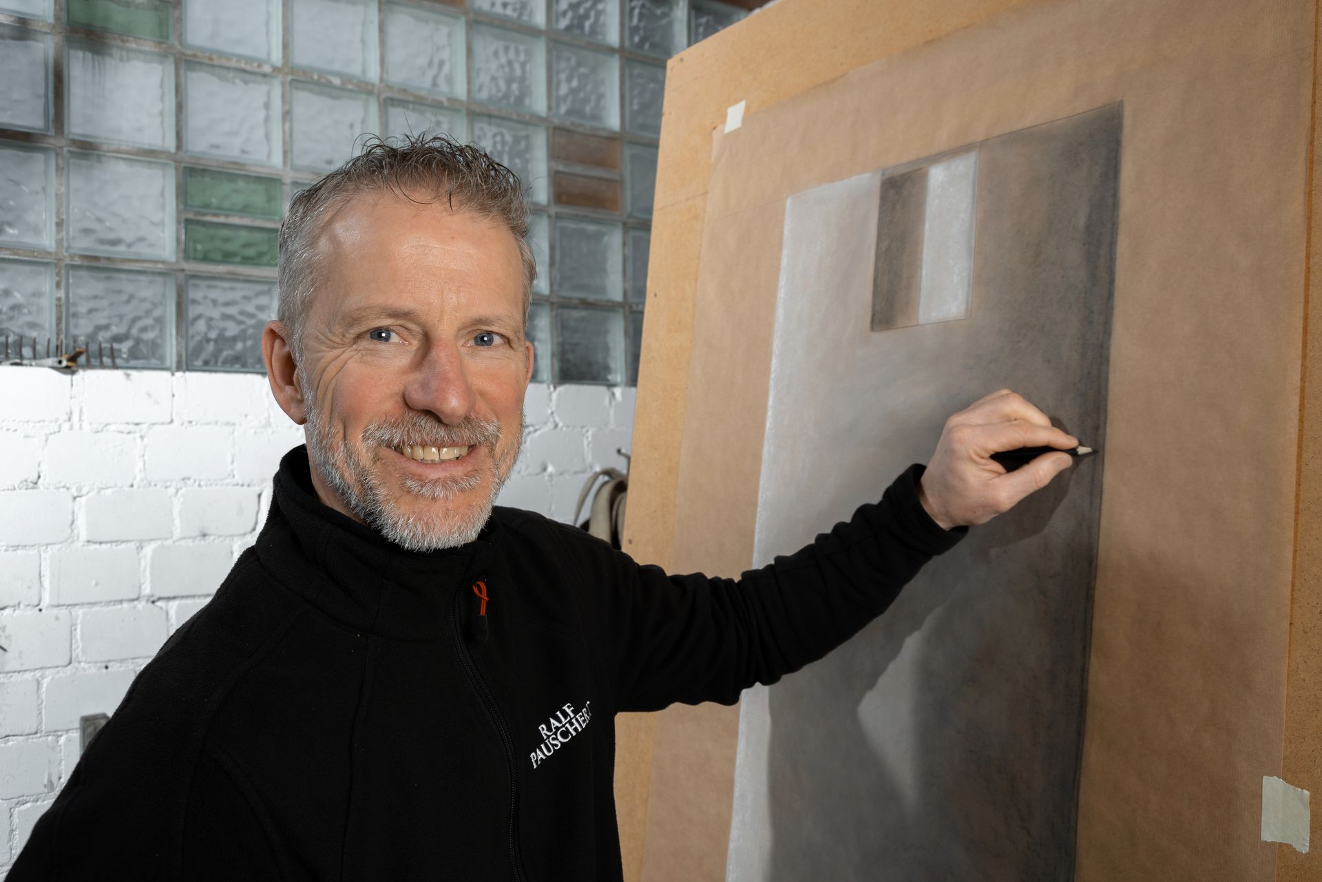 Steinmetz bei der Arbeit an einer Entwurfszeichnung auf einer großen Tafel.