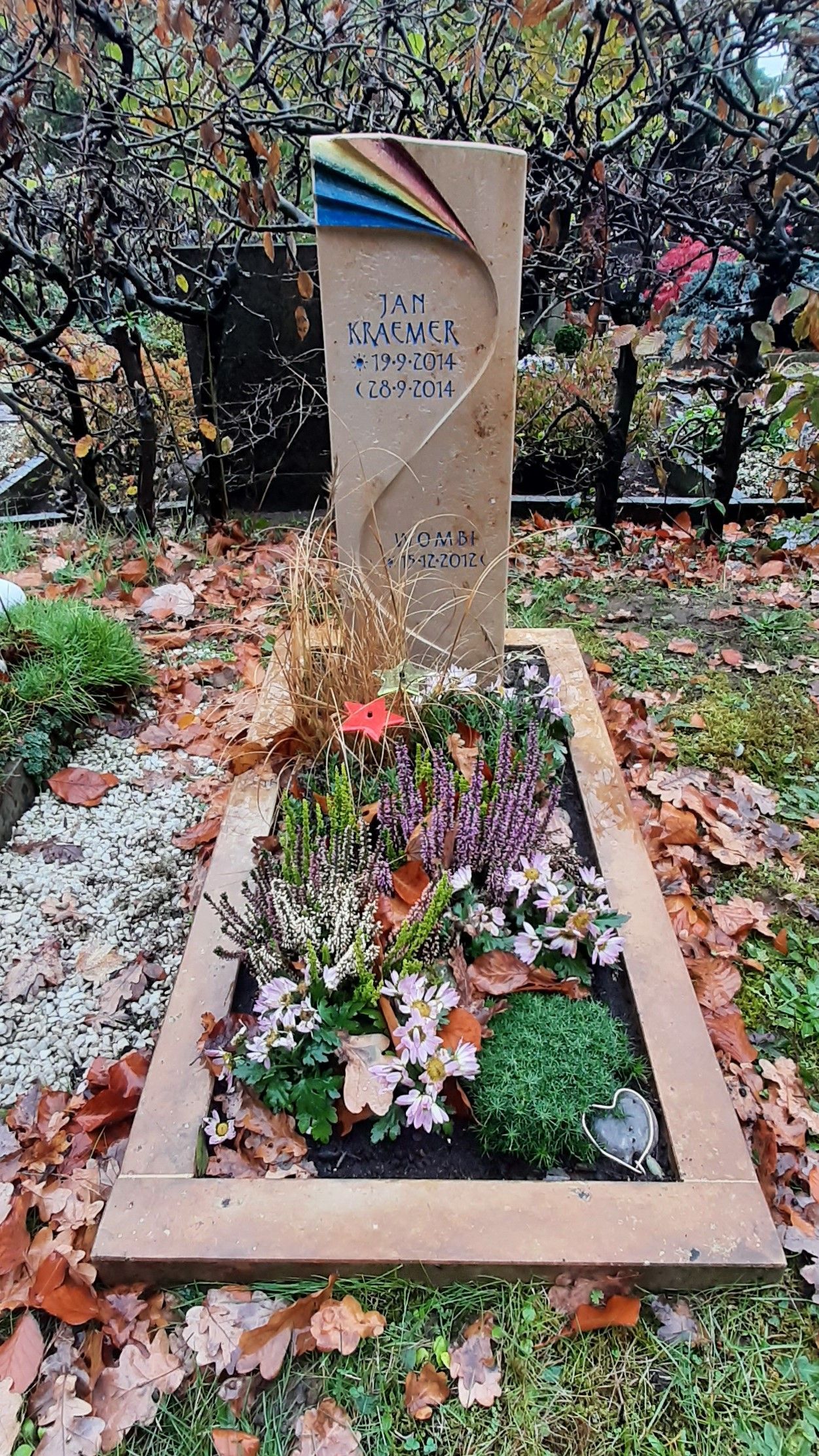 Kindergrabmal aus Naturstein mit eingraviertem Namen und farbigem Regenbogenmotiv