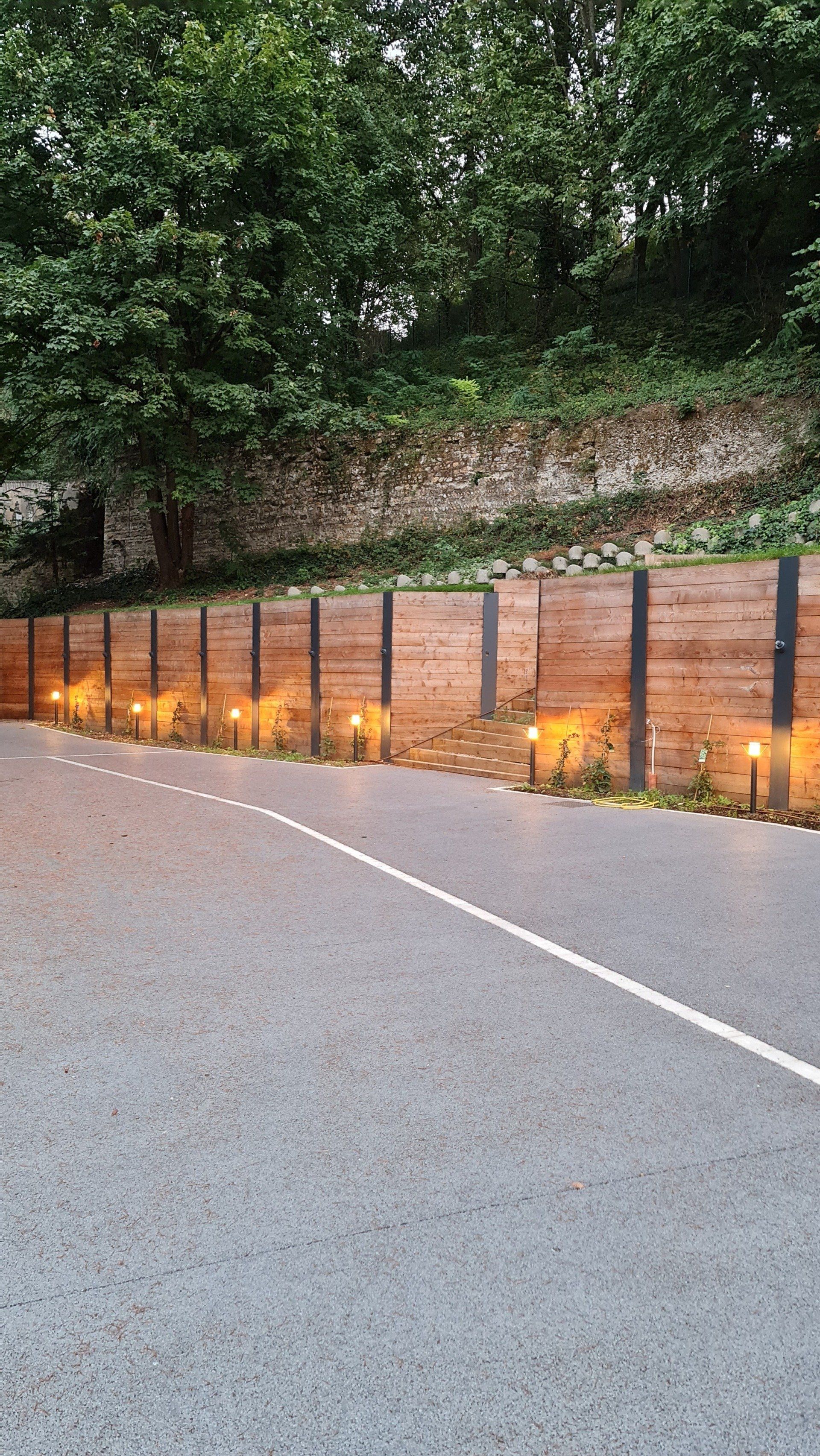 Clôture en bois à côté d'une allée en béton
