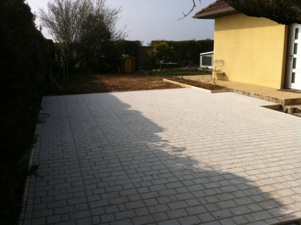 Terrasse en bois terminée près d'une maison jaune