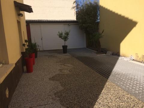 Allée de garage dans des plantes et du gravier