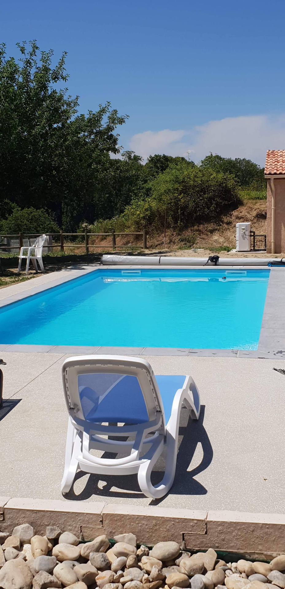 Piscine bleu azur avec des chaises de jardin