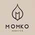 Logotipo de Momko Servics: "M" estilizada marr&oacute;n dentro de un contorno en forma de llama. Texto: "MOMKO SERVICIS" debajo.