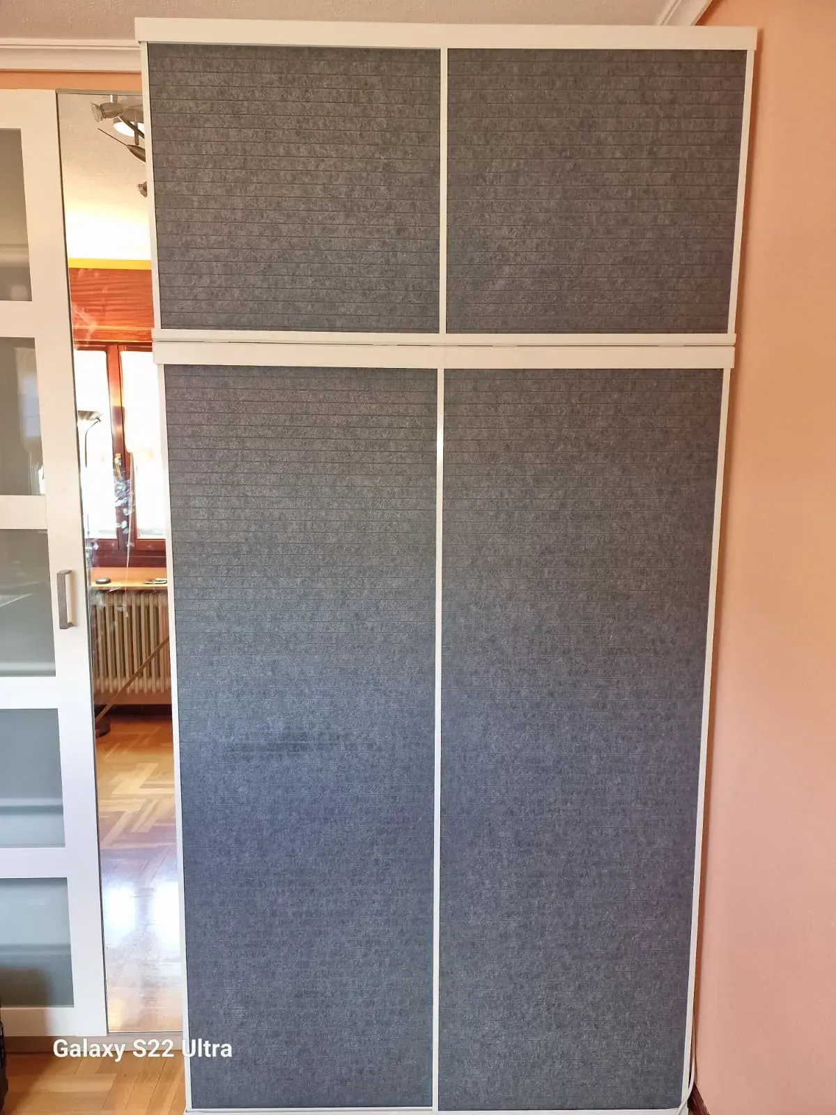 Puertas corredizas de armario de cuatro paneles en color gris y blanco.