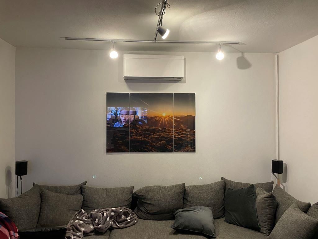 Ein Wohnzimmer mit einer Couch und einem Bild an der Wand