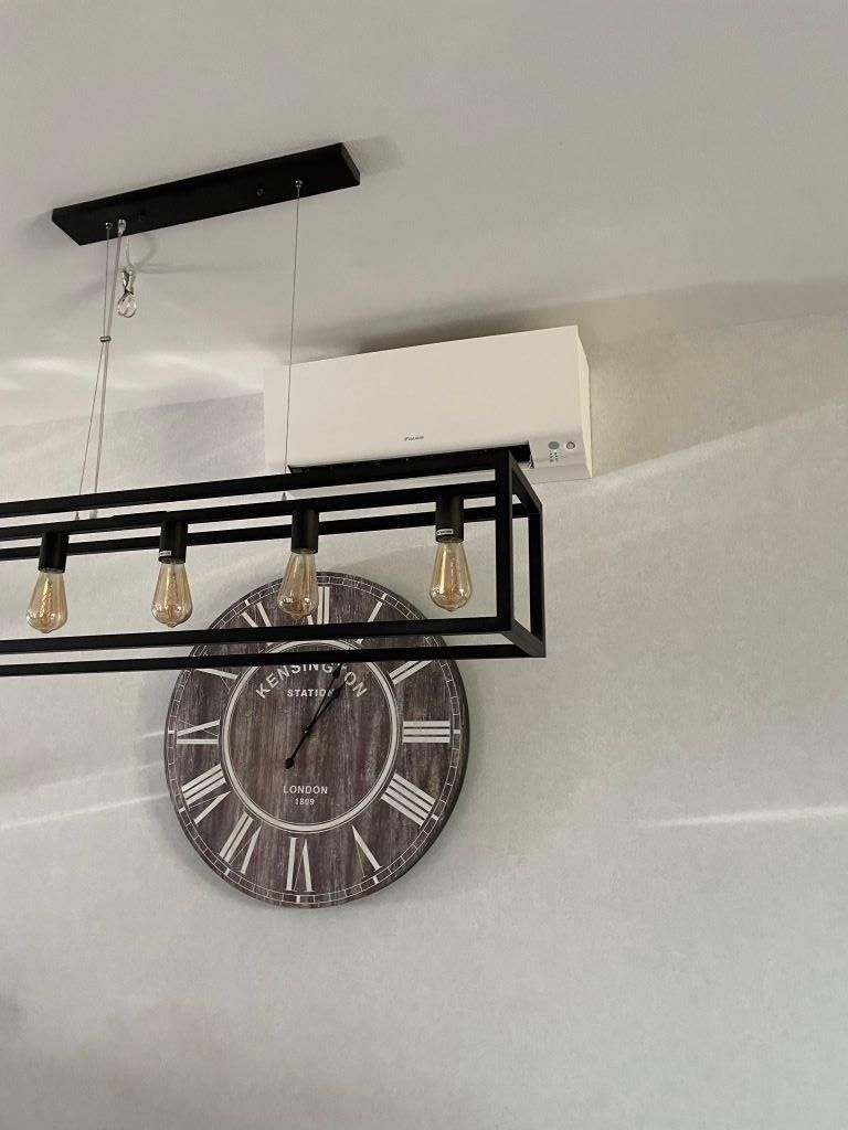 Eine Uhr mit römischen Ziffern hängt von der Decke