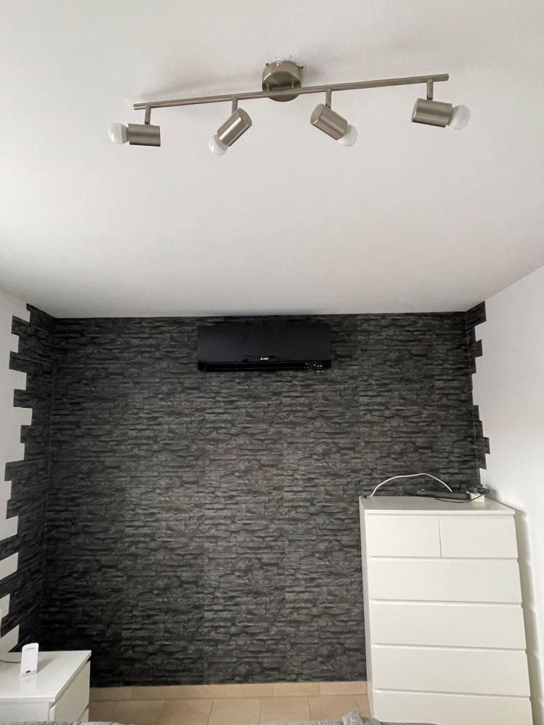 Ein Raum mit einer Ziegelwand und einer Deckenleuchte