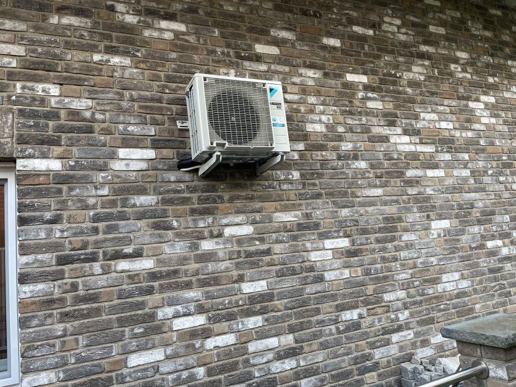 Eine Ziegelwand mit einer darauf montierten Klimaanlage