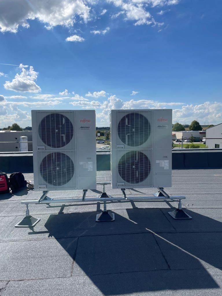 Auf einem Dach stehen zwei Klimaanlagen.